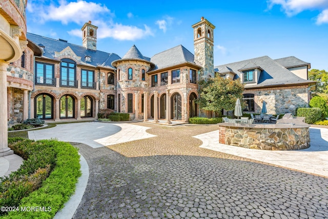86 Montrose Rd, Colts Neck, NJ 07722 - exterior space with a patio area, stone siding, curved driveway, a chimney, and a high end roof