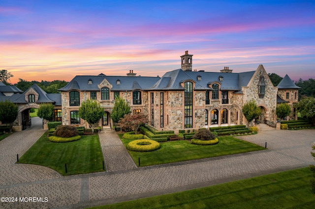 french provincial home with a lawn