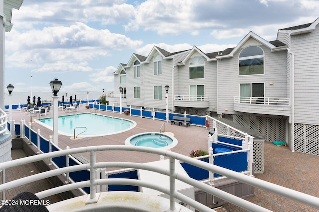 community pool with a community hot tub and a patio