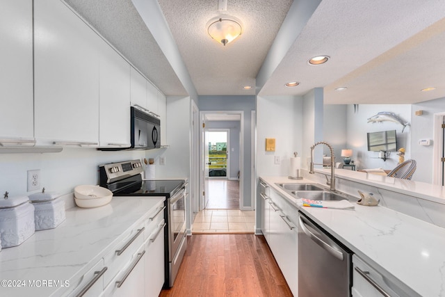 kitchen featuring white cabinets, sink, stainless steel appliances, and a textured ceiling