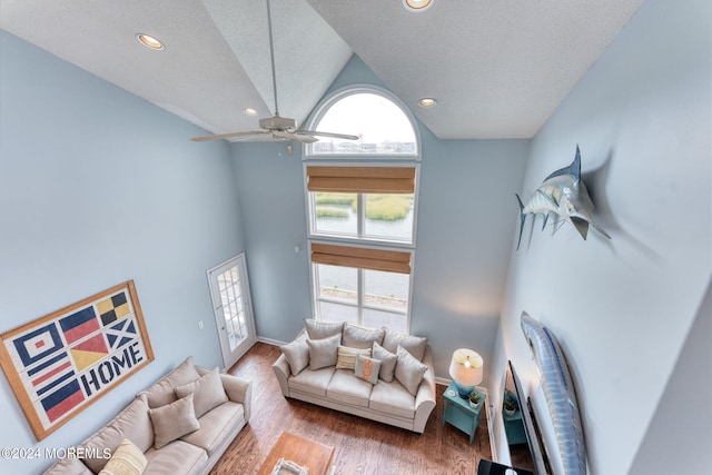 living room with recessed lighting, a high ceiling, a ceiling fan, a textured ceiling, and wood finished floors