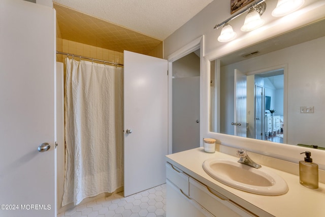 bathroom with tile patterned floors, vanity, a textured ceiling, and a shower with shower curtain