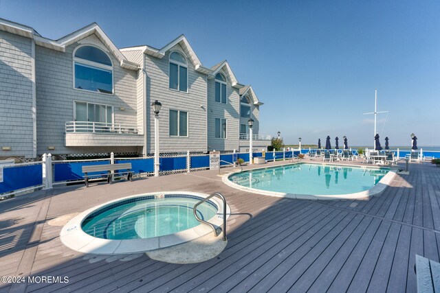 view of swimming pool featuring a hot tub