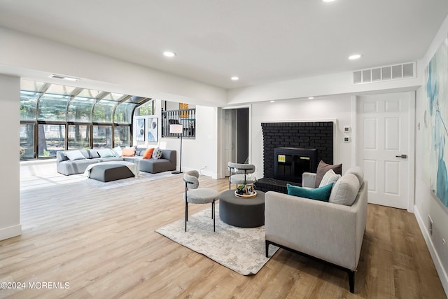 living room featuring light hardwood / wood-style flooring, a healthy amount of sunlight, and a fireplace