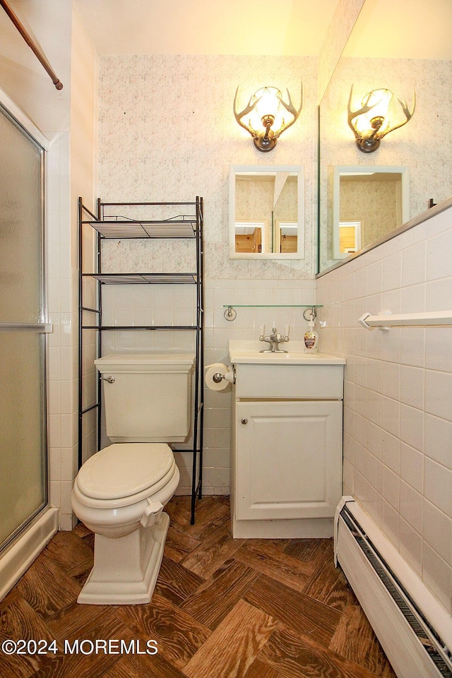 full bath with a baseboard radiator, toilet, vanity, a shower stall, and wallpapered walls