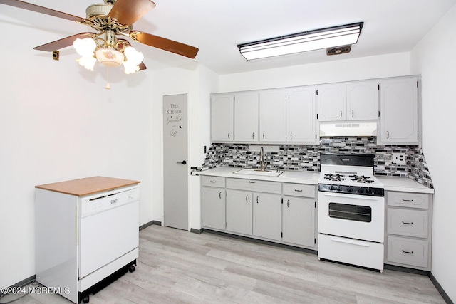 kitchen with white appliances, tasteful backsplash, light countertops, a sink, and exhaust hood