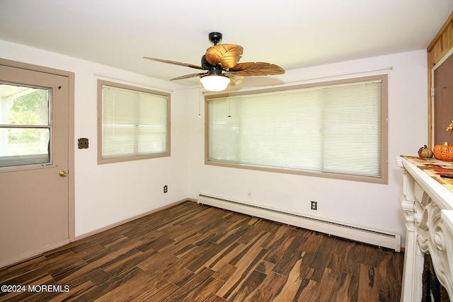 empty room featuring a ceiling fan, baseboard heating, and dark wood finished floors