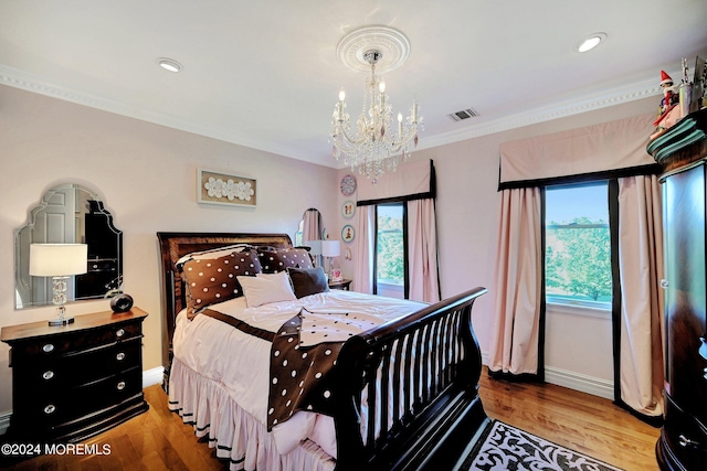 bedroom with visible vents, multiple windows, and wood finished floors