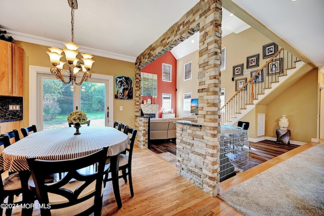 dining space with baseboards, stairway, crown molding, light wood-style floors, and a notable chandelier