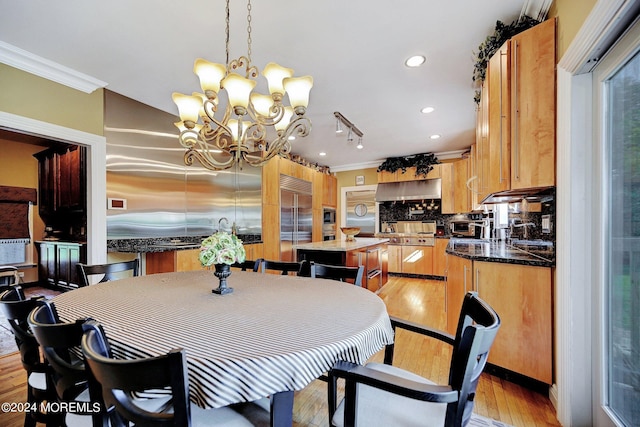 dining area featuring ornamental molding, recessed lighting, a notable chandelier, and light wood finished floors