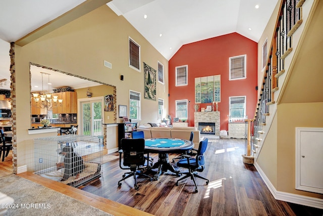 dining area featuring high vaulted ceiling, a fireplace, wood finished floors, visible vents, and stairs