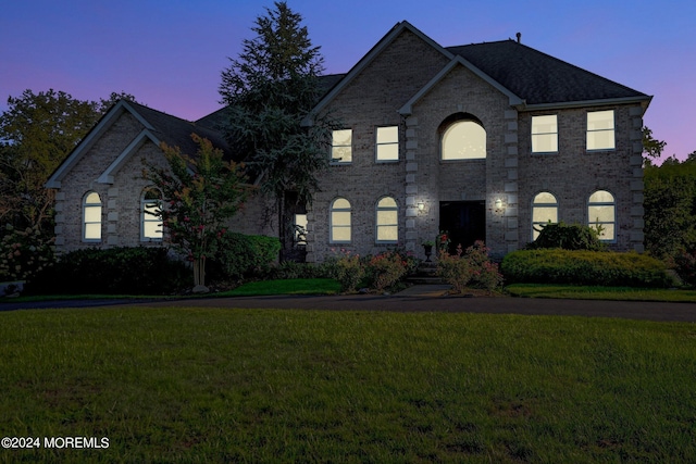 view of front facade featuring a yard and brick siding