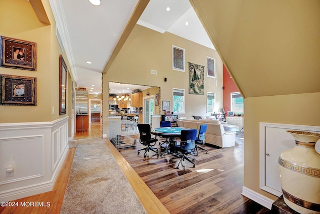 dining room with a decorative wall, recessed lighting, light wood-style floors, vaulted ceiling, and wainscoting