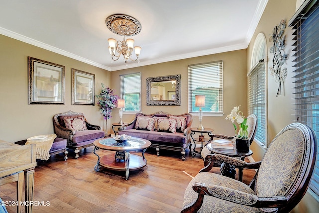 living area with ornamental molding, hardwood / wood-style flooring, and an inviting chandelier