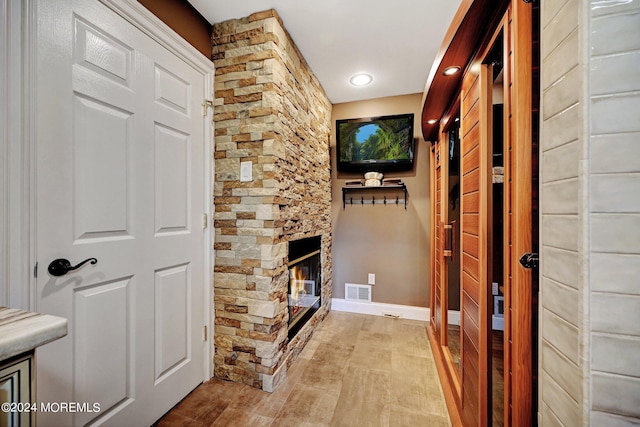 hallway with light wood-type flooring, visible vents, and baseboards