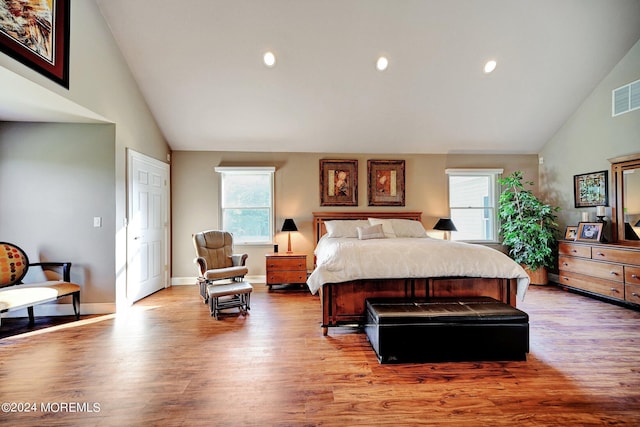 bedroom with high vaulted ceiling, recessed lighting, wood finished floors, visible vents, and baseboards