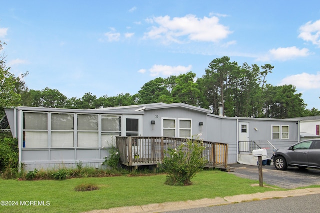 manufactured / mobile home featuring a deck and a front yard