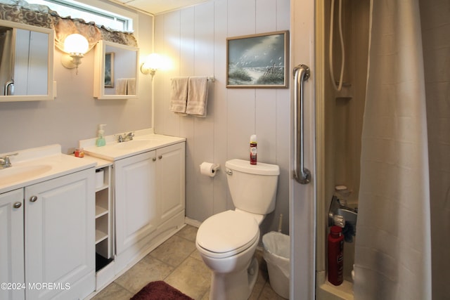 bathroom with toilet, a shower with shower curtain, vanity, and tile patterned floors