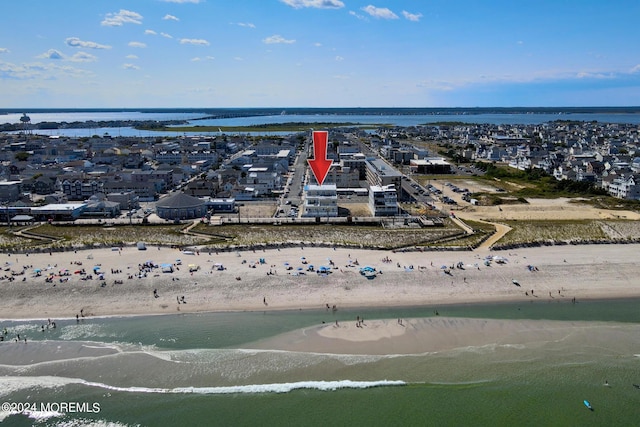 birds eye view of property featuring a beach view and a water view