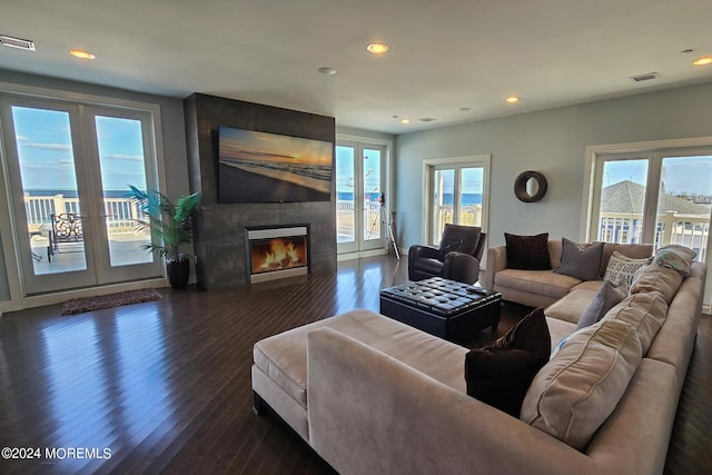 living room with recessed lighting, dark wood-style floors, visible vents, and a large fireplace