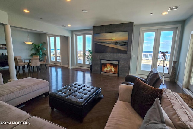 living area featuring a fireplace, wood finished floors, visible vents, and baseboards