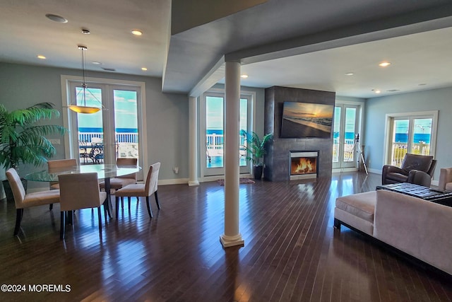 living area featuring baseboards, a fireplace, and dark wood-style flooring