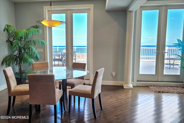 dining area featuring french doors, dark wood-style flooring, ornate columns, and baseboards