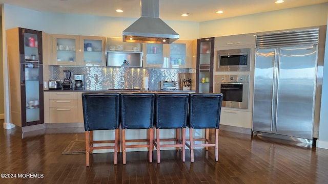 kitchen featuring backsplash, built in appliances, island exhaust hood, modern cabinets, and dark wood-style flooring