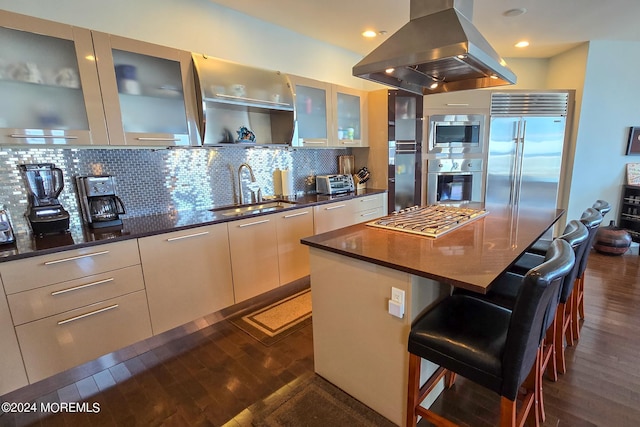 kitchen with backsplash, dark wood-style flooring, island range hood, modern cabinets, and a sink