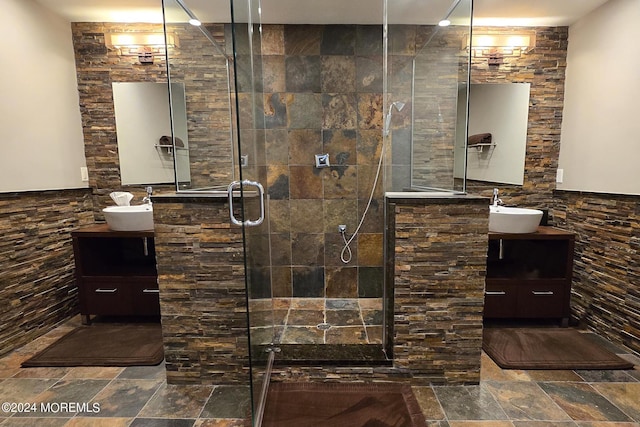 bathroom featuring stone tile flooring, a stall shower, and vanity