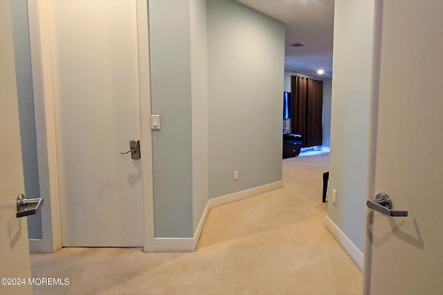 hallway featuring baseboards and carpet flooring