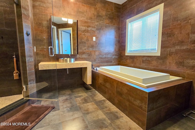 bathroom featuring tile walls, a bath, and a tile shower