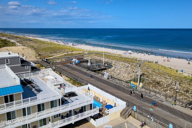 bird's eye view featuring a water view and a beach view