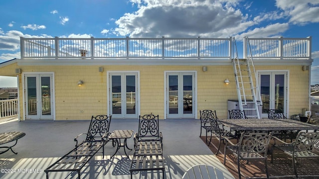 exterior space featuring french doors, a balcony, outdoor dining space, and a patio area