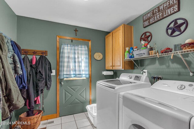 laundry area featuring cabinet space, visible vents, light tile patterned flooring, and washing machine and clothes dryer