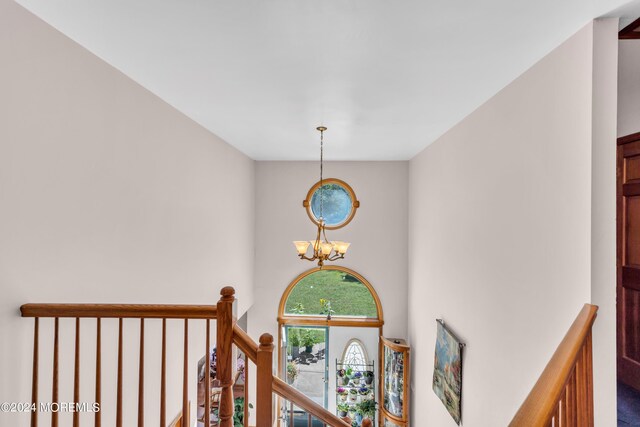 interior space featuring a notable chandelier, a towering ceiling, and an upstairs landing