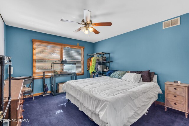 bedroom with baseboards, dark carpet, visible vents, and a ceiling fan