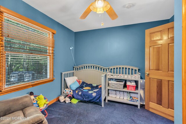 bedroom featuring ceiling fan, baseboards, and dark colored carpet