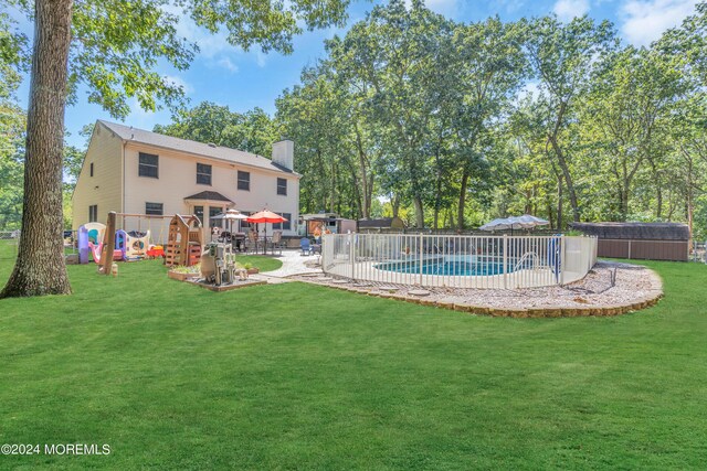 view of swimming pool with a fenced in pool, a playground, a yard, a hot tub, and a patio area