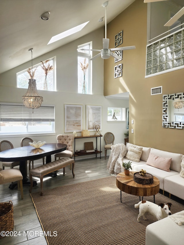 interior space with light hardwood / wood-style floors, high vaulted ceiling, a skylight, and ceiling fan