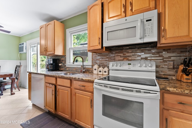 kitchen with backsplash, light tile patterned floors, sink, dark stone countertops, and white appliances