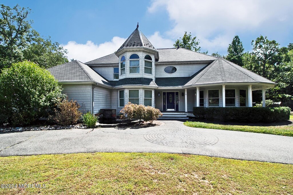 rear view of property featuring a lawn