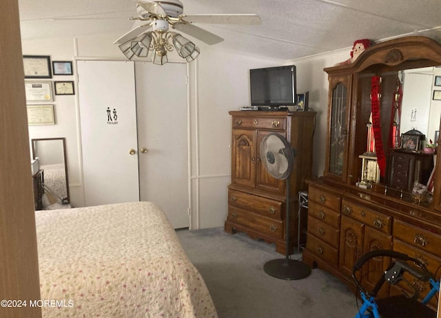 carpeted bedroom with ceiling fan and a textured ceiling