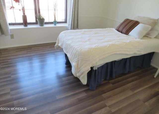 bedroom featuring dark wood-type flooring and multiple windows