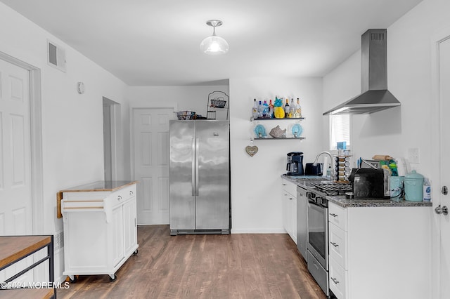 kitchen featuring stainless steel appliances, dark wood-type flooring, white cabinetry, a sink, and wall chimney exhaust hood