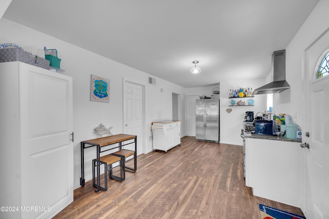 kitchen featuring extractor fan, wood finished floors, white cabinets, freestanding refrigerator, and open shelves