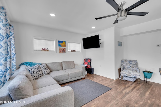 living area with baseboards, wood finished floors, and recessed lighting