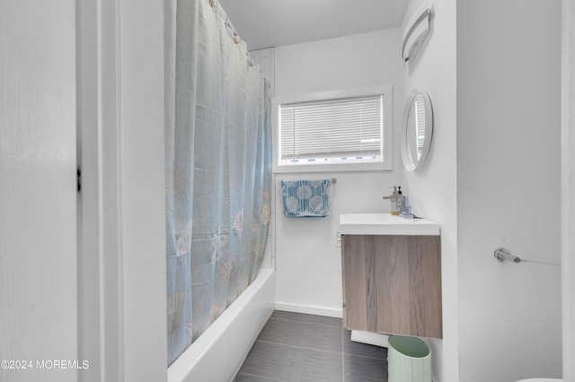 bathroom featuring tile patterned floors, baseboards, shower / bath combination with curtain, and vanity