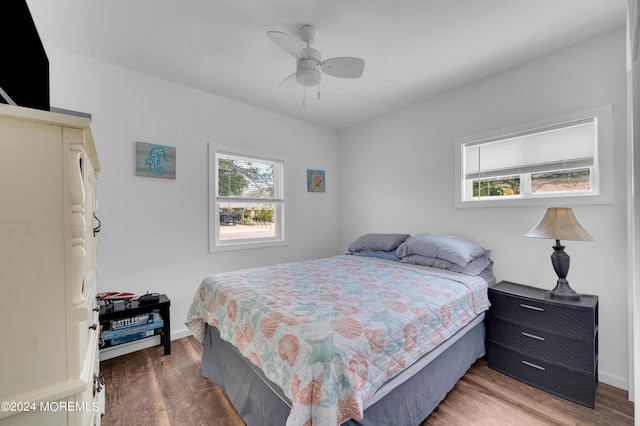 bedroom with ceiling fan, baseboards, and wood finished floors