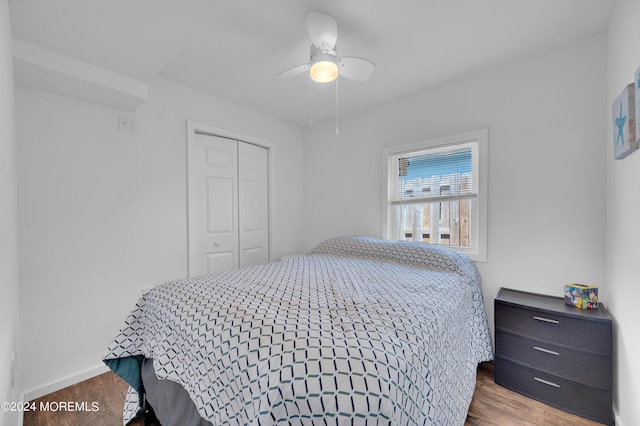 bedroom featuring baseboards, a closet, a ceiling fan, and wood finished floors